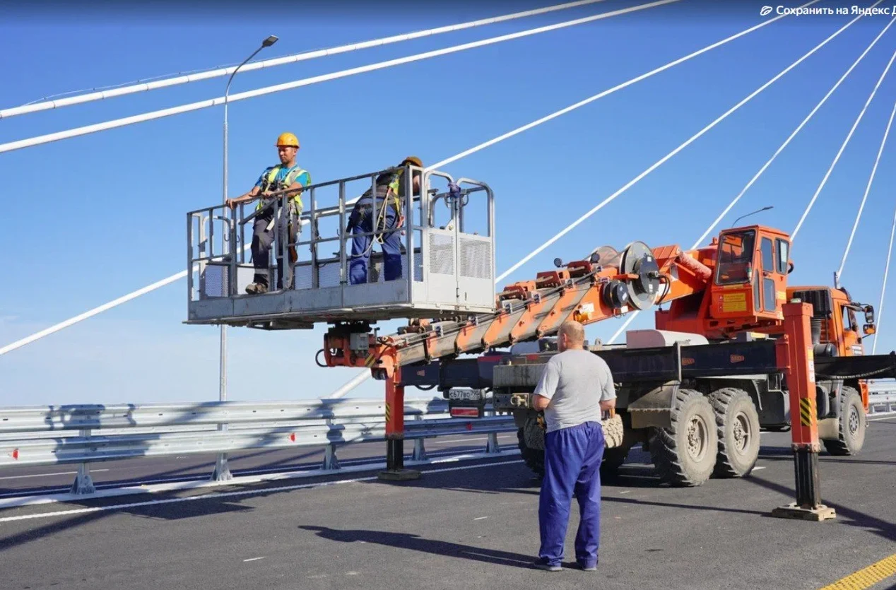 workers on boom lift during bridge maintenance